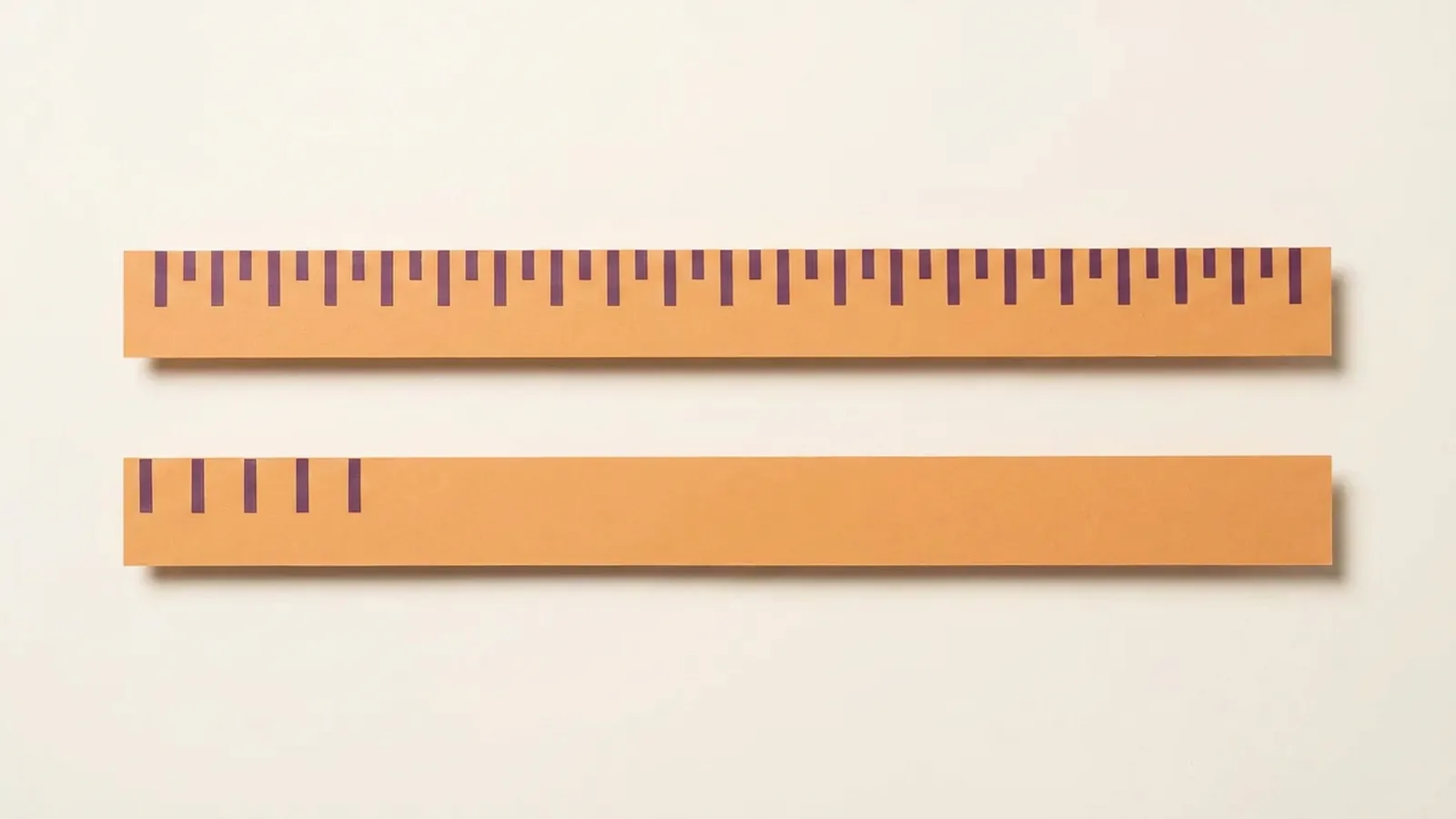Paper-craft illustration of two rulers lying side by side, one fully graduated and the other carrying only its first few marks